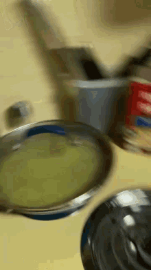 a bowl of soup sits on a counter next to a can of spaghetti