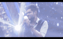 a man singing into a microphone with the words super singer visible in the corner