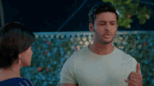 a man in a white shirt is talking to a woman