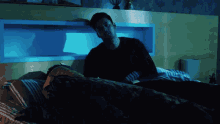 a man in a black shirt is standing next to a woman in a bed