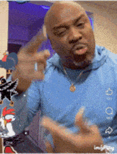 a man in a blue shirt is pointing his finger
