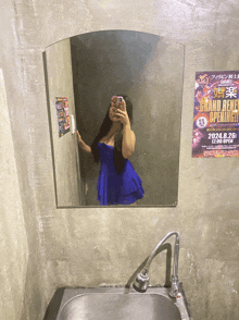 a woman taking a picture of herself in front of a poster that says grand benel opening
