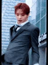 a man in a suit and tie is standing in front of a building that says the center .