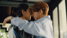 a couple of men are hugging each other and looking at each other .