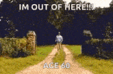 a man is walking down a dirt road with a sign that says `` im out of here ! ''