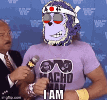a man wearing a purple shirt that says achd man is holding a microphone