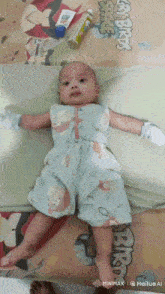 a baby is laying on a bed with a pillow that says angry birds on it