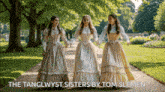 the tanglwyst sisters by tom slemen shows three women in historical dresses walking down a path