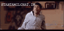 a man in a striped shirt is dancing in front of a sign that says " starttamilchat in "