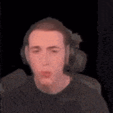 a man wearing headphones is making a funny face in a blurry photo .