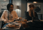 a woman wearing a sweater that says read return repeat sits at a table with other people