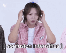 a man in a pink plaid shirt holds his hands to his head and says i confusion intensifies ]