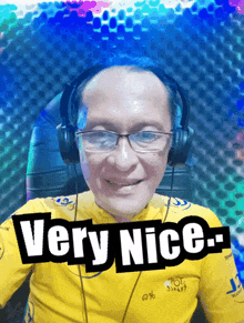 a man wearing headphones and a yellow shirt that says very nice on it