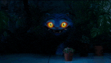 a blue cat with orange eyes is standing in front of a potted plant