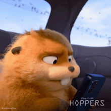 a stuffed animal from the movie hoppers is holding a cell phone