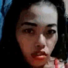 a close up of a woman 's face with a blurred background .