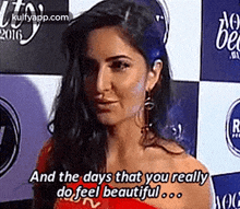 a woman in a red dress is standing in front of a wall and says `` and the days that you really do feel beautiful ... ''