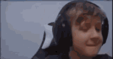 a close up of a person wearing headphones and making a funny face .