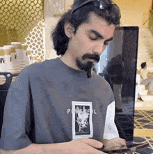 a man wearing a shirt that says powerful is using a tablet