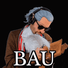 a man wearing headphones and sunglasses is holding a piece of paper with the word bau written above him
