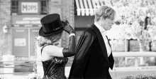 a man and a woman are standing next to each other in front of a building .