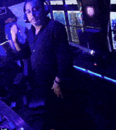 a man wearing headphones is dancing in front of a slot machine that has the letter l on it