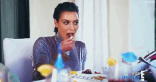 a woman is sitting at a table with a plate of food in front of her .