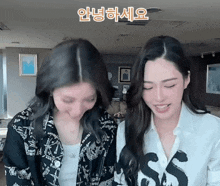 two women are standing next to each other in a room and one of them is wearing a shirt that says sss