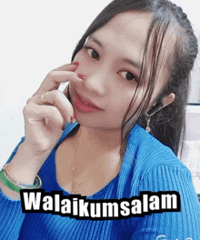a woman wearing a blue sweater has a sticker that says ' awalikumsalam ' on her face