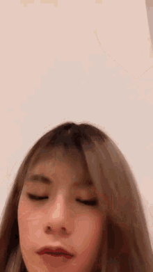 a close up of a woman 's face with her eyes closed and her hair blowing in the wind .