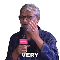 a man wearing glasses and a plaid shirt is holding a pink villa microphone