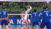 a volleyball game is being played in front of a banner that says ana on it
