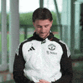 a man wearing a black and white adidas jacket with the number 7 on the front