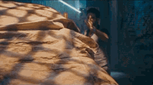a man is hiding behind a blanket in a room .