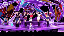 a group of girls are performing on a stage with a sbs pop logo on the bottom right