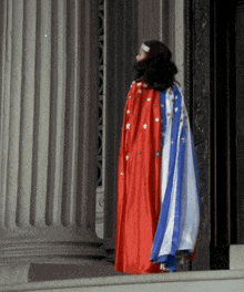 a woman wearing a red white and blue cape