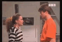 a man and a woman are standing next to each other and looking at each other