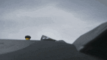 a gray background with a few clouds and a yellow object in the foreground