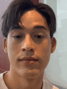 a close up of a man 's face with a white shirt on .