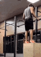 a man is standing on a box in a gym