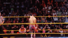 a woman in a wrestling ring is wearing a shirt that says ' i am livin '