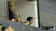 a man and a woman are watching a game with a sign that says las noticias on it