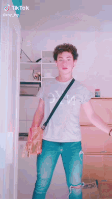 a young man with curly hair and blue eyes is making a funny face while wearing headphones .