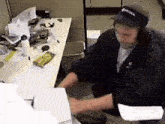 a man wearing headphones is sitting at a desk .