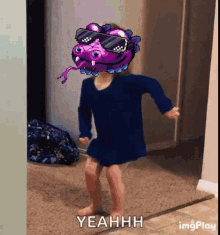 a little girl wearing sunglasses and a purple monster head is dancing and says yeahh