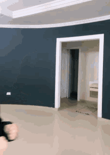 an empty room with a blue wall and a white doorway