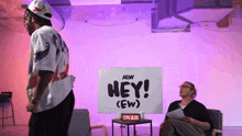 a man standing in front of a sign that says hey ew