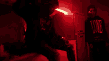 a man is standing in a dark room with a red light shining on him .