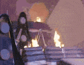 a person is walking down a set of stairs with flames coming out of them