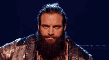a man with a beard is looking at the camera with a serious look on his face